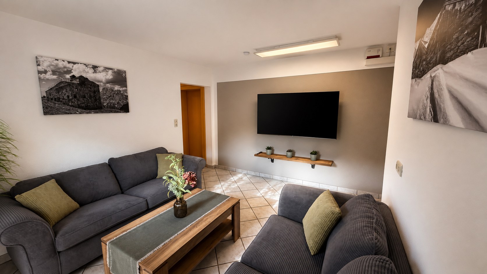 Living room of the holiday apartment with two seating areas, a coffee table and Smart TV
